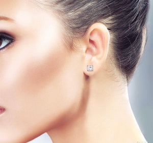 Round diamond stud earrings set in 14kt gold on a ladies ear